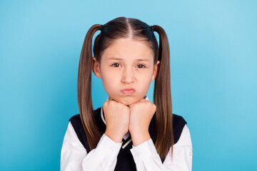 Photo of unhappy upset small girl hold hands fists face negative bad mood isolated on pastel blue color background