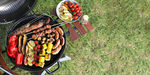 Tasty meat and vegetables on barbecue grill outdoors, top view