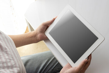 タブレット端末を使うシニア女性の手元（日本人、60代）