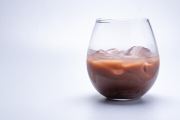 Water, cocoa, iced in a round transparent glass on a white background.