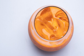 Iced tea in a round clear glass, top view. on a white background