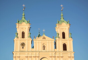Fototapeta premium Towers of an ancient gothic catholic basilica on a blue sky background