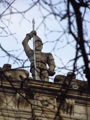 Fototapeta na wymiar Betonowa statua średniowiecznego żołnierza na dachu budynku we Lwowie, Ukraina