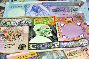 Background of Libyan money dinars banknotes with portraits of Omar Al-Mukhtar and Muammar Gaddafi...