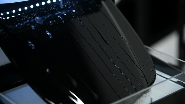 Video showing advantages of using ceramic coating on mini car hood. Hydrophobic effect on water pouring on metal surface