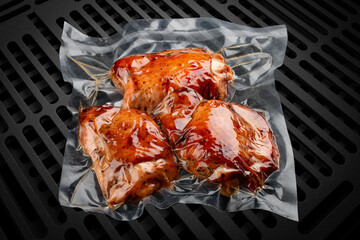 Vacuum-packed grilled meat, on a dark background, chicken fillet. Ready to eat.