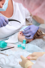 The child is under anesthesia. Caries treatment of primary teeth under general anesthesia....