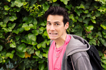 shocked young man on a green plants background