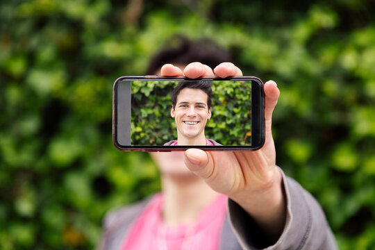 happy man covering face with a photo at phone