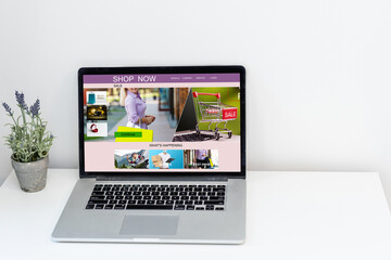 shopping, technology and internet concept. shopping with laptop computer on a fictional shop