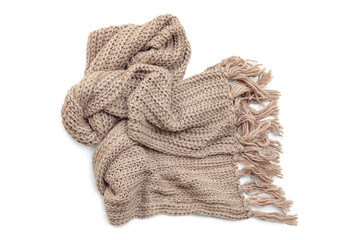 Beige woolen knitted scarf with tassels on white background, top view.