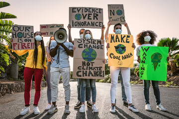Group of activists protesting for climate change during covid19 - Multiracial people fighting on road holding banners on environments disasters - Global warming concept - obrazy, fototapety, plakaty