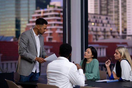 Diverse group of business colleagues working at night having meeting