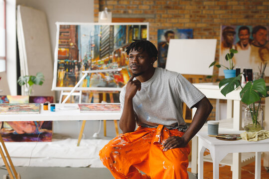 African American Male Painter At Work Sitting And Thinking In Art Studio