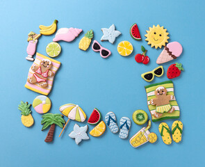Gingerbread man, gingerbread woman with various summer theme cookies on blue background