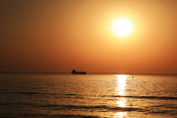 Obraz premium sunrise at sea and ship on the horizon