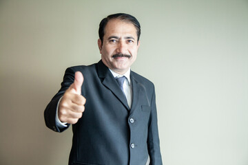 Smart mature older business man with moustache showing a thumbs up wearing suit and tie