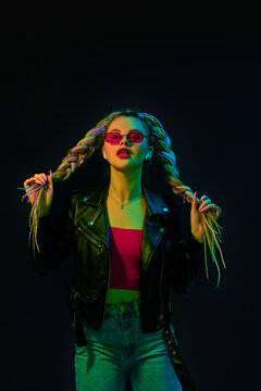 young woman with dreadlocks in red sunglasses dancing