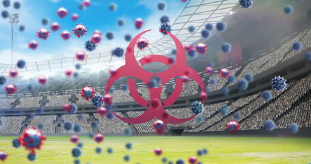Bio hazard symbol and Covid-19 cells against empty sports stadium