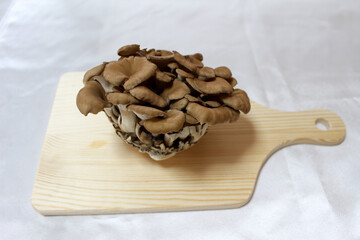 木製のまな板に乗ったまいたけ