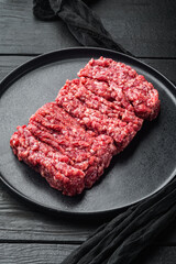 Minced marble beef, on black wooden table background