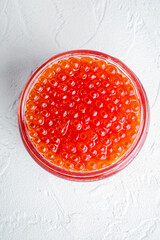 Red salmon caviar, on white background, top view flat lay