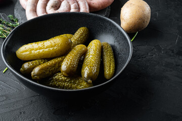 Homemade canning. Marinated cucumbers gherkins, on black background