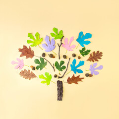 Creative season of colorful summer and autumn leaves and branches in pastel modern colors. Seasonal concept. Flat laid wood. An optimistic tree.