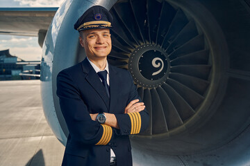 Cheerful aviator posing for the camera after the flight