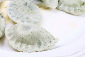 Green dumplings with spinach on the plate.