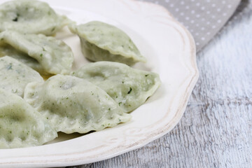 Green dumplings with spinach on the plate.