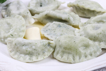 Green dumplings with spinach on the plate.