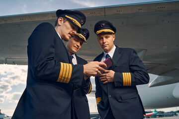 Three airmen viewing photographs on the smartphone © Viacheslav Yakobchuk