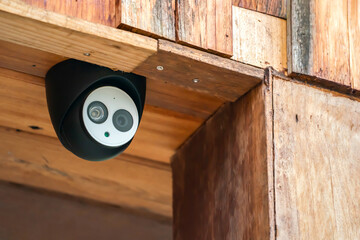 close up mini CCTV camera black case is set up on the wood ceiling building.