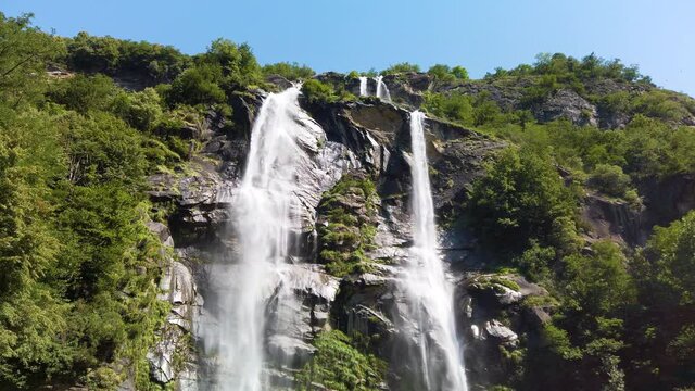 Water stream running from the beautiful Acquafraggia waterfall in Piuro, in the Bregaglia valley in Italy, before the ascent to the Maloja pass. It is a beautiful sunny summer day.