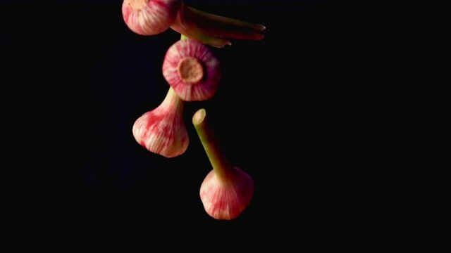 Super slow motion garlic falls on a black background. Filmed on a high-speed camera at 1000 fps. High quality FullHD footage