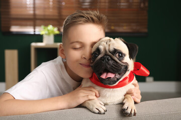 Little boy with cute pug dog at home