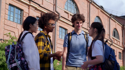 Group of happy young friends standing in college campus and talking.