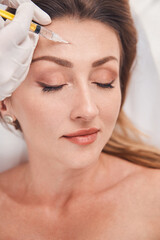 Happy pretty woman doing anti wrinkles procedures