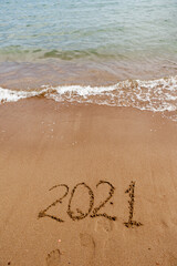 inscription on the sand 2021. symbol 2021 on the coast, overlooking the sea. Summer holidays in the new season.
