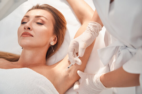 Beautician doing anti sweat injections in female armpit