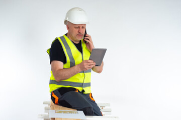 Architect in a yellow vest. Architect is talking on phone. Man in uniform next to construction...