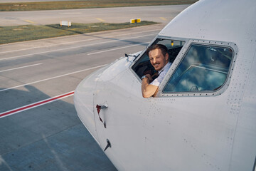 Fototapeta na wymiar Joyous aviator posing for the camera from the flight deck