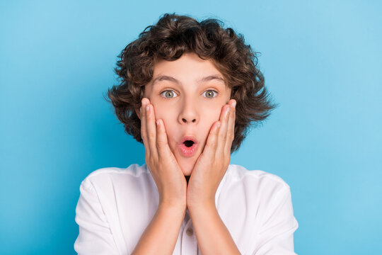 Photo of impressed funky schoolboy wear white shirt smiling arms cheeks isolated blue color background