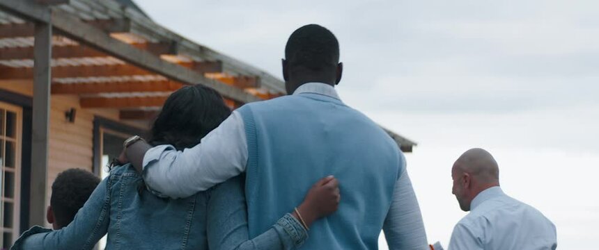 TRACKING Real estate agent showing African American family of three, husband wife and son, a beautiful country house. Shot with 2x anamorphic lens