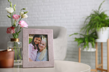 Framed family photo on light table in living room. Space for text