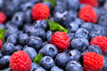 Blueberry and Raspberry with mint background. Top view. Close up view of fresh ripe mixed berries