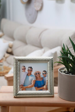 Framed family photo on wooden table in living room
