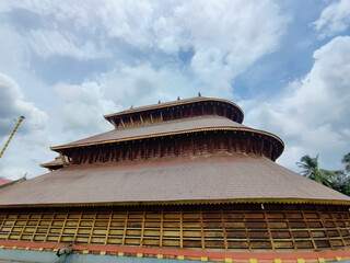 Beneath the sky is a view of an ancient Hindu temple rich in beautiful carvings. The architectural work done on the wood is incredible. Adoor Temple Kerala boarder