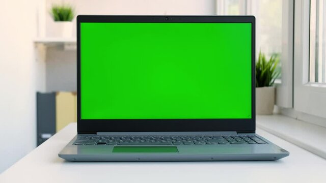 Close up laptop green screen. Chroma key green screen computer set up for work on desk at home, technology concept 4k video template